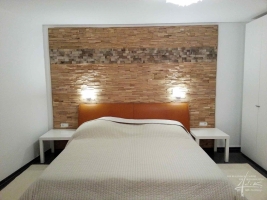 Schlafzimmer mit einer Holzwand