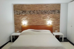 Schlafzimmer mit einer Holzwand